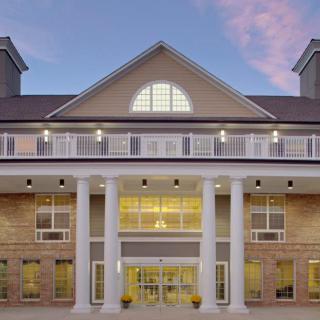 Grand entrance of a hotel with prominent columns and warm lighting during the evening.
