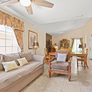 Cozy living room with a sofa, chairs, and dining area.