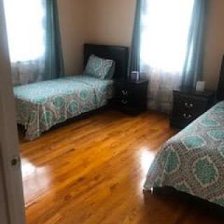 A cozy bedroom with twin beds and hardwood flooring.