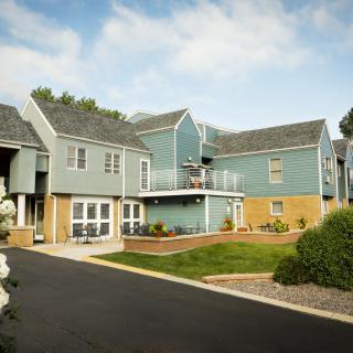 A modern apartment complex with well-maintained landscaping on a sunny day.