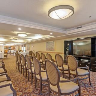 A well-lit conference room with rows of chairs set up for a meeting or event.