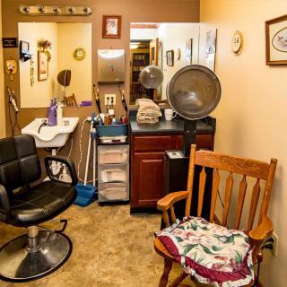 Cozy hair salon interior with a styling chair, mirror, and hair dryer.
