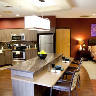 A modern kitchen with an open-concept design, featuring sleek appliances and a dining area.