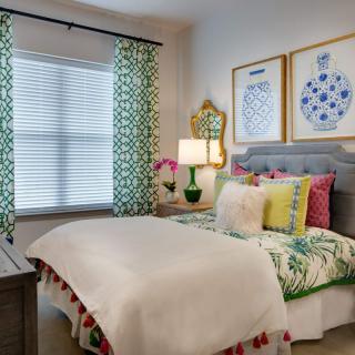 A cozy bedroom with colorful decor and patterned curtains.
