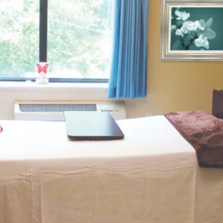 A serene massage room with a treatment bed and calming decor.