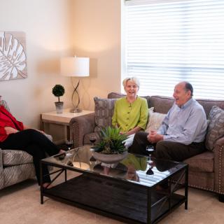 Three people sitting in a living room having a conversation.