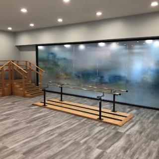 A contemporary interior featuring a wooden structure and a glass wall, illuminated by modern lighting.