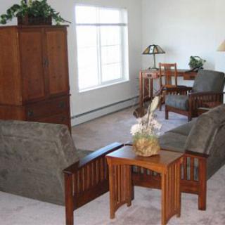 A cozy living room with wooden furniture and natural lighting.