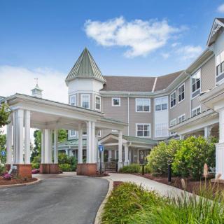 A well-maintained retirement home with landscaped gardens and a covered entrance.