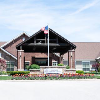 Entrance of a residential facility with beautiful landscaping and an American flag.