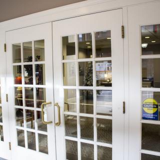 White framed glass-paneled doors leading into an office space.