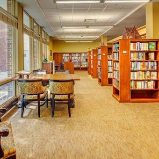A serene library setting featuring shelves filled with books and comfortable seating for reading and study.