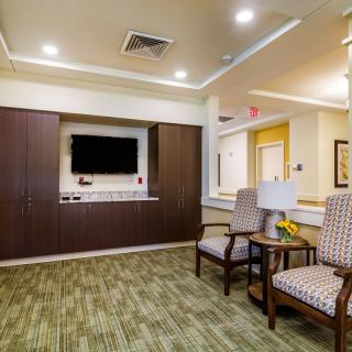 A modern lobby area with comfortable seating and a wall-mounted TV.