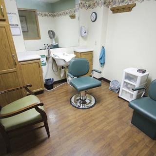 A small dentist office with a chair and medical equipment.