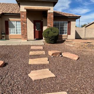 A welcoming front yard with a stone pathway leading to the entrance of the house.