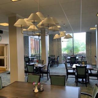 An empty dining area with tables, chairs, and large windows.