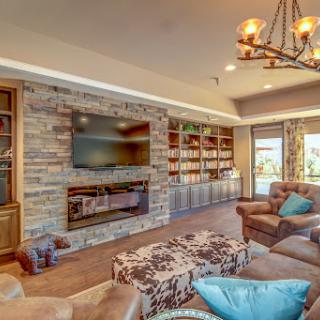 A cozy and modern living room featuring a stylish stone fireplace, built-in bookshelves, and comfortable seating.