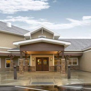 The front entrance of a modern building featuring stone accents and a sloped roof.