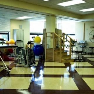 A rehabilitation center with various exercise equipment and therapy areas.
