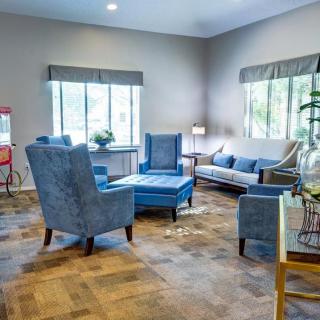A cozy living room with blue furniture and large windows.