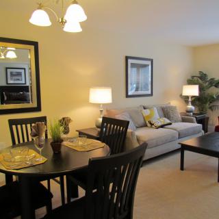 A cozy living and dining area featuring a sofa, dining table, and ambient lighting.