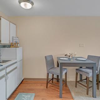 A small kitchen and dining area with a table, chairs, and cabinets.
