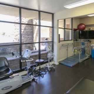 A well-equipped physical therapy room with various exercise machines and tools.