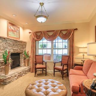 A cozy living room with a stone fireplace and elegant furnishings.