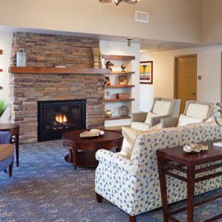 A cozy living room with a stone fireplace and comfortable seating.
