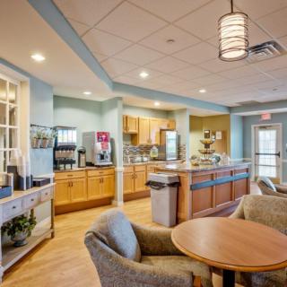 A modern kitchen with a seating area and coffee station.