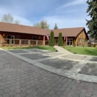 A spacious countryside house with a paved driveway and manicured lawn.