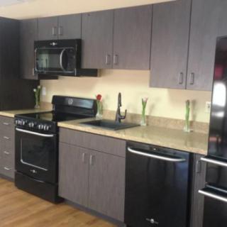 A modern kitchen with dark cabinets and sleek appliances.