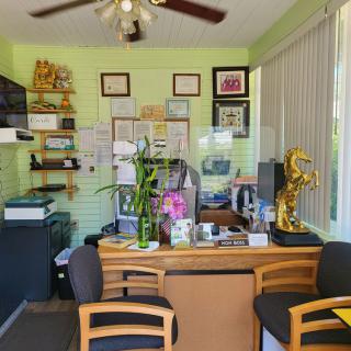 A small, brightly lit office with a desk, chairs, and various decorations.