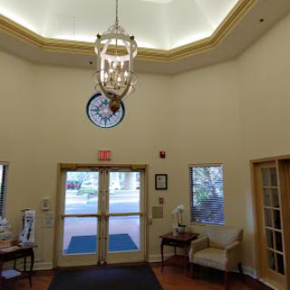 A welcoming lobby featuring a chandelier and a decorative clock.