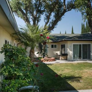 A backyard view of a house with a garden and patio area.