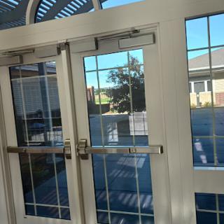 A view of glass doors with a reflection of the outside scenery.