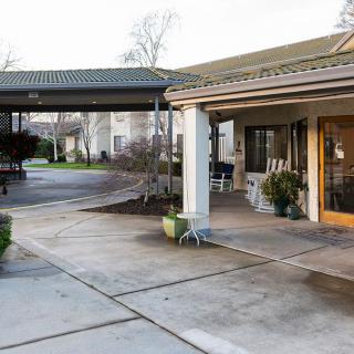 A driveway leading to the entrance of a building with a covered walkway.