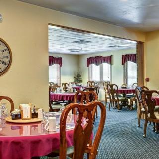 A cozy dining area with elegantly set tables and classic wooden chairs.