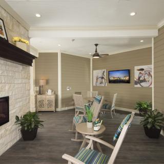 A cozy living room with modern decor, featuring a fireplace, seating area, and wall-mounted television.
