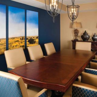 A stylish dining room with a wooden table, upholstered chairs, and decorative wall art.