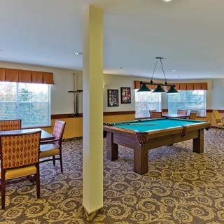 A cozy game room featuring a pool table and seating areas.