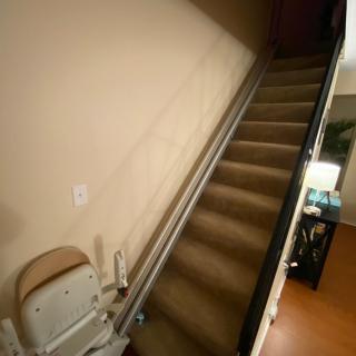 An interior staircase equipped with a chair lift for accessibility.