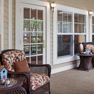 A cozy porch with wicker chairs and decorative pillows, perfect for relaxation.