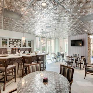 A stylish bar interior with modern seating and a decorative ceiling.