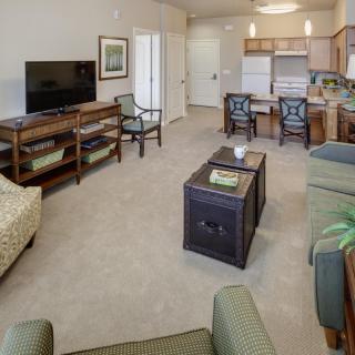A spacious living area with an open kitchen and dining setup, featuring comfortable seating and modern appliances.