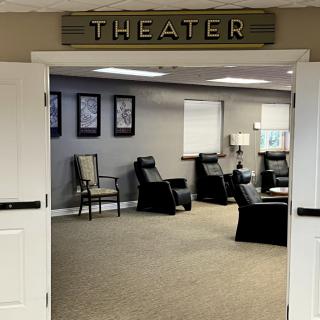 A modern theater room with recliner seating and stylish decor.