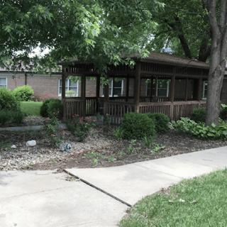A charming wooden house surrounded by lush greenery and a neatly maintained garden.