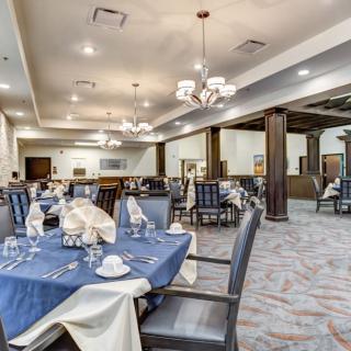 An elegantly set indoor dining area with tables and chairs.