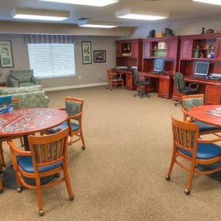 A spacious community room with tables, chairs, and computer stations.