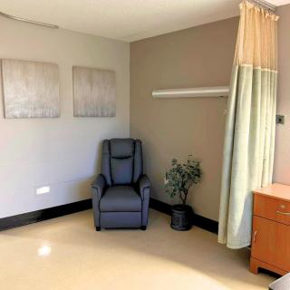 A hospital room with a comfortable chair and minimalist decor.